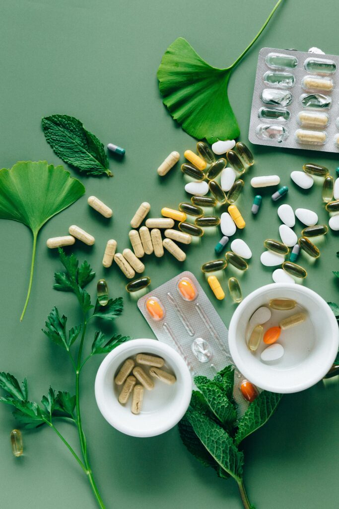 A collection of longevity supplements including omega-3 softgels, vitamin D tablets, magnesium capsules, CoQ10 and probiotics displayed on a clean white surface
