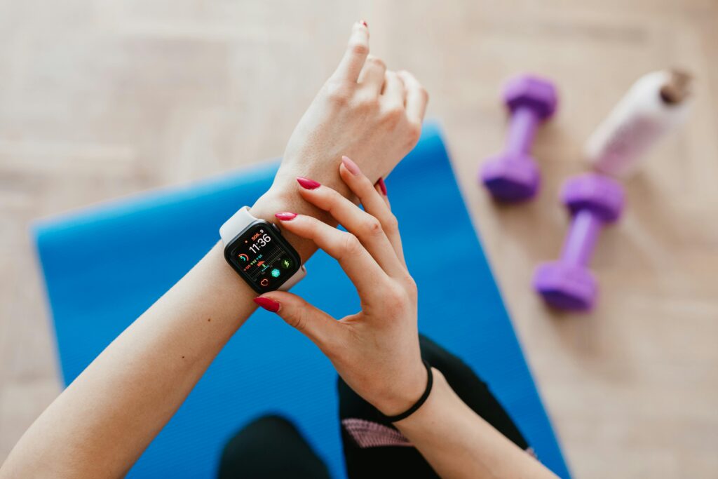 Woman checking fitness and heart rate data on her smartwatch during a home workout.