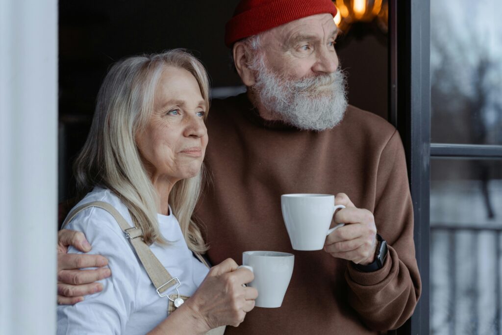 An older couple sharing a relaxed moment with coffee, representing wellbeing and active ageing.
