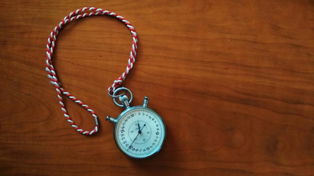 Close up shot of an antique stopwatch on a wooden table, symbolising meal timing.